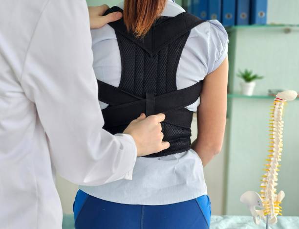 istock Orthopedist helping patient to put on posture corrector in clinic, closeup 2186830964
