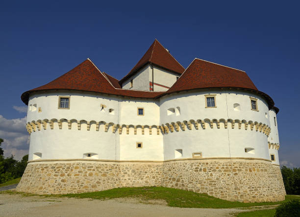 People walk below Veszprem Castle in Veszprem, Hungary on a cloudy day.