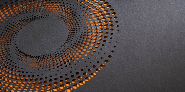 istock Abstract black paper cut artwork with circular perforations and glowing orange background highlights 2186837545
