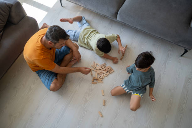 istock Father and boys playing with wooden cubes 2186841167
