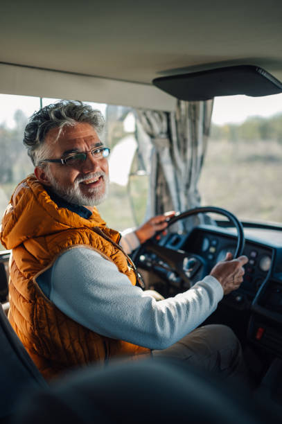 istock Senior bus driver smiling and driving public transportation vehicle 2186847502