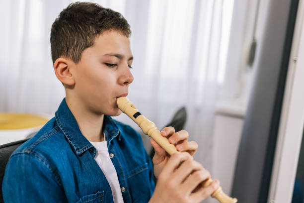 istock Boy plays flute at home. 2186847861
