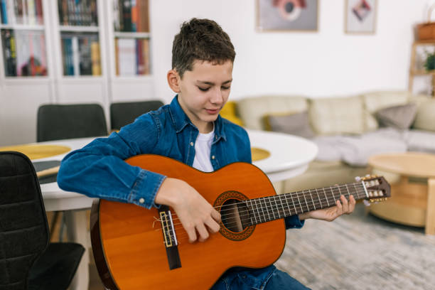 istock Boy plays guitar at home. 2186847987