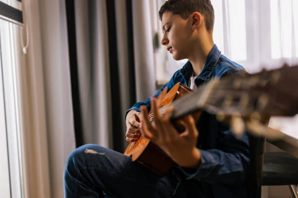 istock Boy plays guitar at home. 2186848272