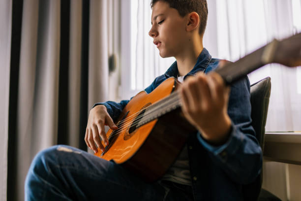 istock Boy plays guitar at home. 2186848277
