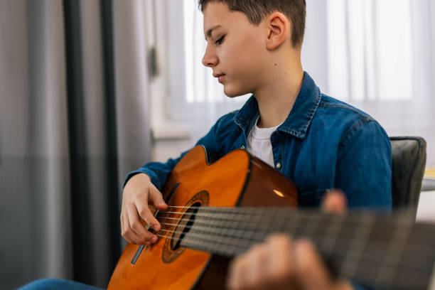 istock Boy plays guitar at home. 2186848285