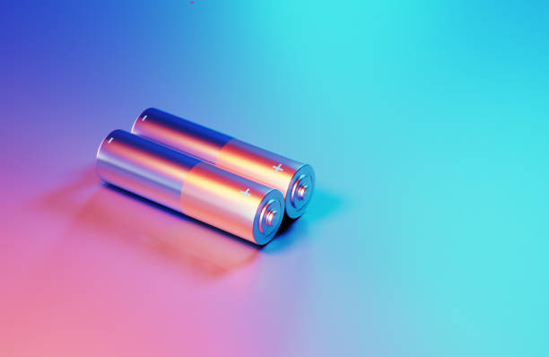 Batteries illuminated by blue and pink lights on blue and pink background. Horizontal composition with copy space. High angle view.