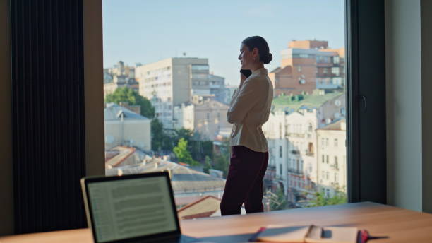 istock Business owner talking smartphone standing in modern office in skyscraper. 2186851505