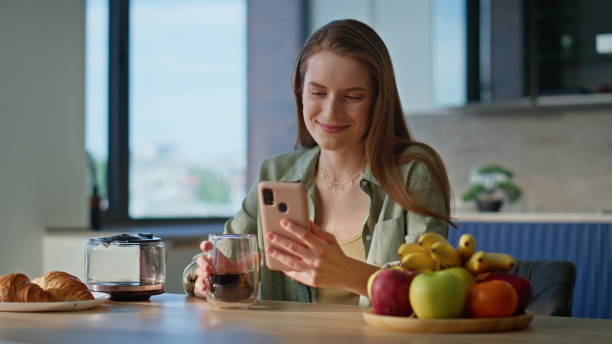 istock Happy woman sitting breakfast table looking smartphone with smile closeup. 2186852230