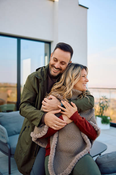 istock Happy couple embracing while enjoying on a balcony. 2186856033