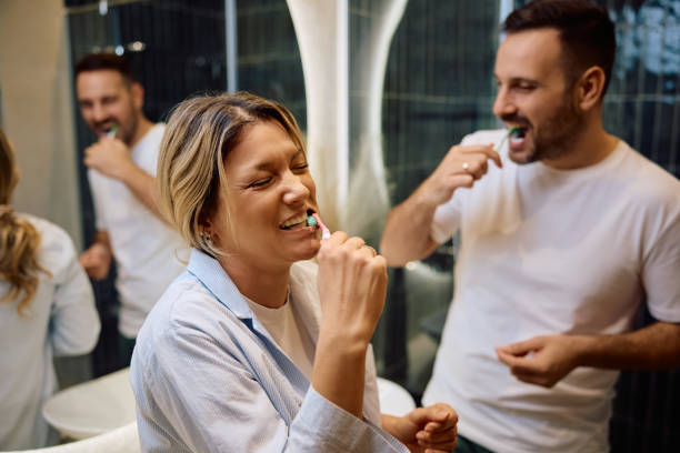 istock Happy woman laughing while brushing teeth with her husband in the morning. 2186856133