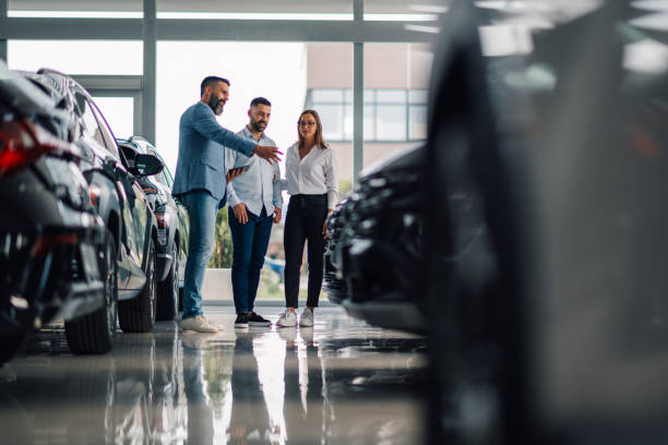 istock Car dealer passionately discussing car options with visitors. 2186859071