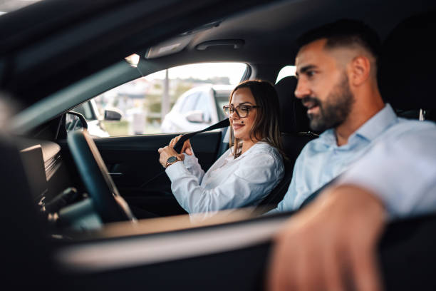 istock Woman adjusting car seatbelt, sharing smile with man driver 2186859112