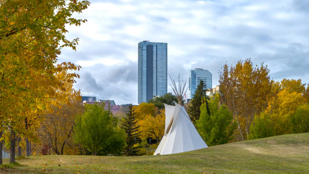 City of Edmonton park with tipi contrasted with skyscraper on background and fall colors trees