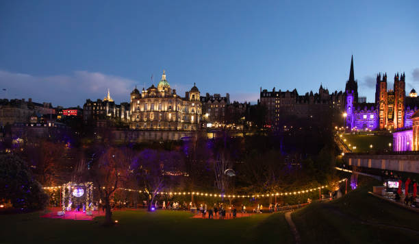 A view down the lenghth of Princes Street after sunset, with motion blur on a the car, bus and tram lights in  long exposure.