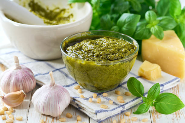 istock Traditional italian sauce pesto in a bowl with basil leaves on a light kitchen table table. 2186860484