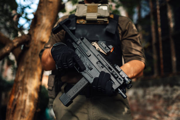 istock Soldier holding a submachine gun in the forest 2186860685