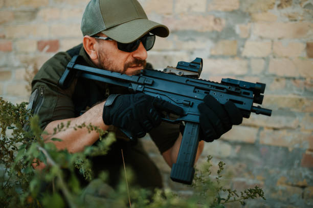 istock Soldier aiming with assault rifle near brick wall 2186860718