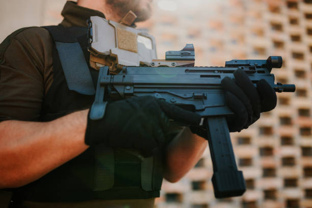 istock Soldier holding a submachine gun with a red dot sight during a military operation 2186860743
