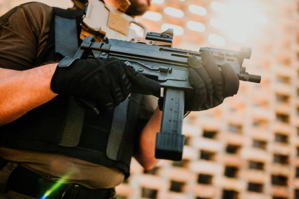 istock Soldier holding a submachine gun in front of a building 2186860764