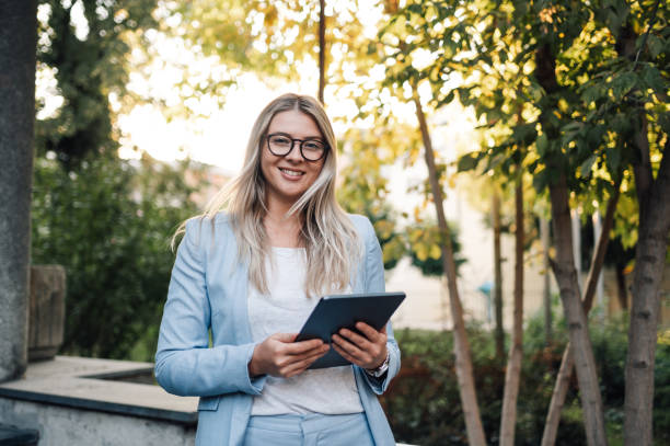 istock Smiling businesswoman using digital tablet in a park 2186861470