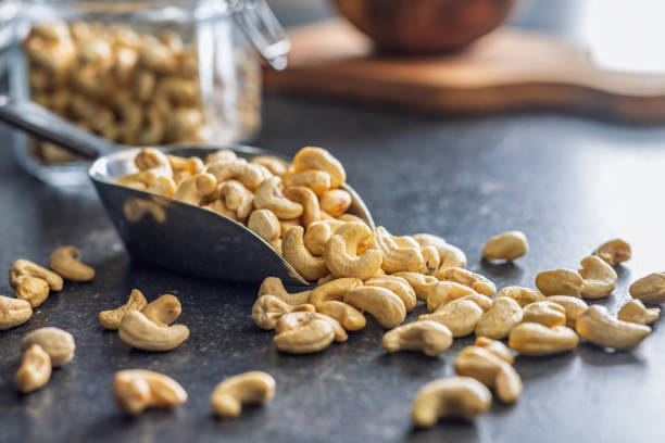 istock Roasted cashew nuts in scoop on black table. 2186861509
