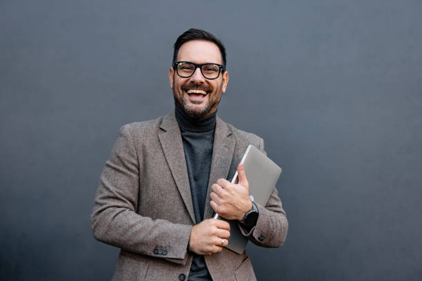 istock Smiling man in glasses holding a laptop, joyful expression 2186864858