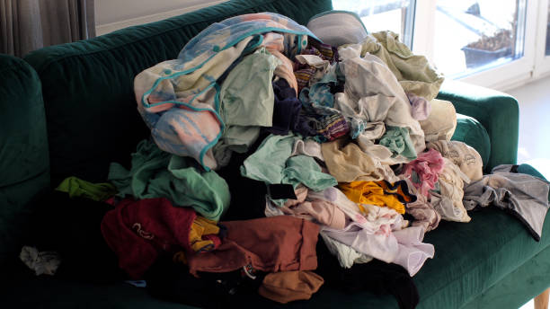 istock Big pile of clean clothes lying on a couch, laundry waiting to be folded 2186864863