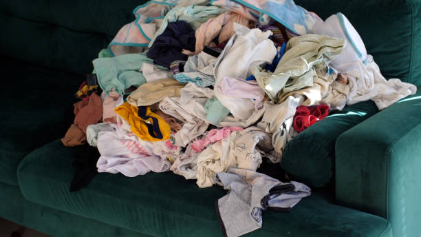 istock Big pile of clean clothes lying on a couch, laundry waiting to be folded 2186864871