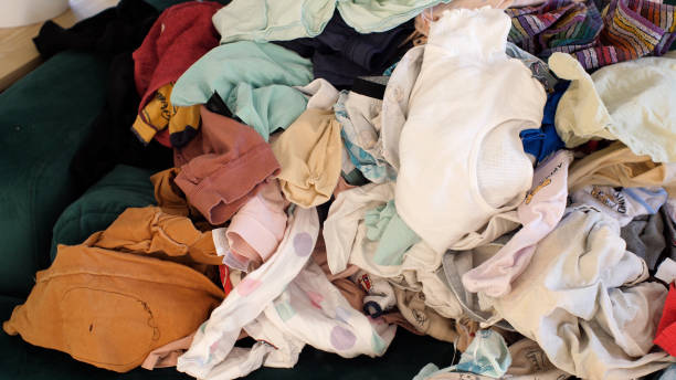 istock Big pile of clean clothes lying on a couch, laundry waiting to be folded 2186864880