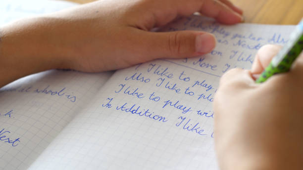 istock Close up of a young girls hand writing in a notebook, kid doing homework 2186865152