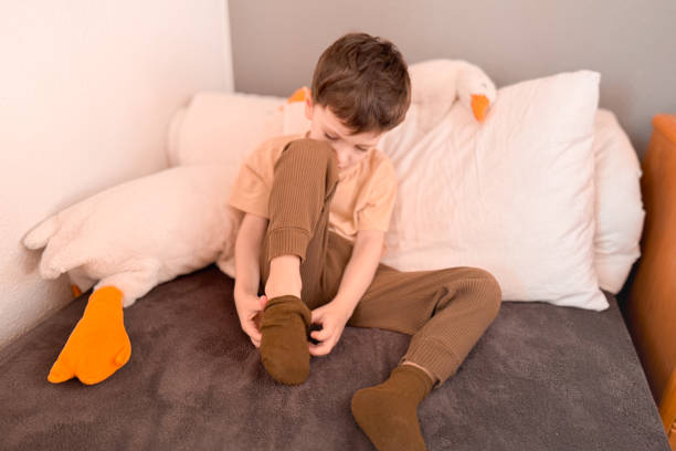 istock An adorable little asian boy putting on socks, getting ready for school. Montessori practical life skills, Self-care, Child development, Fine motor, Hand eye coordination, Kids daily routine concept. 2186867602