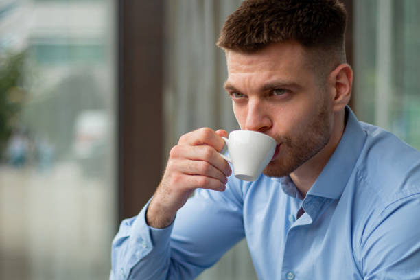 istock Young Businessman Drinking Coffee, Serious and Confident, in Cafe During Business Break 2186867683