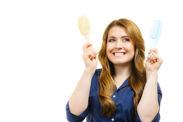Haircut coiffure haircare concept. Woman with long brown wavy hair holding brush and comb.