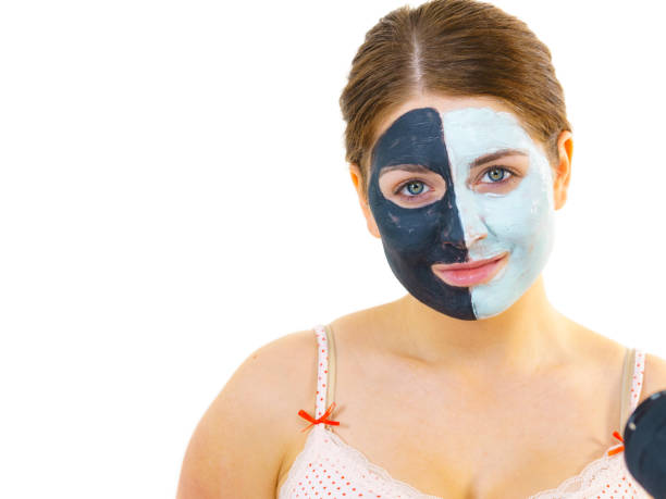 istock Girl with black white mud mask on face 2186871888