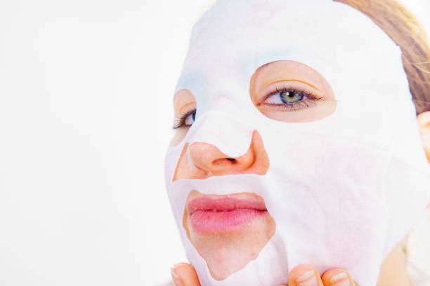 Woman with sheet mask on her face. Girl taking care of skin. Beauty treatment. Skincare.
