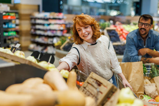 istock Young couple choosing fresh vegetables at the supermarket 2186871981
