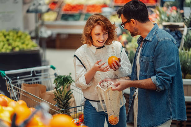istock Young couple choosing oranges at grocery store 2186872008