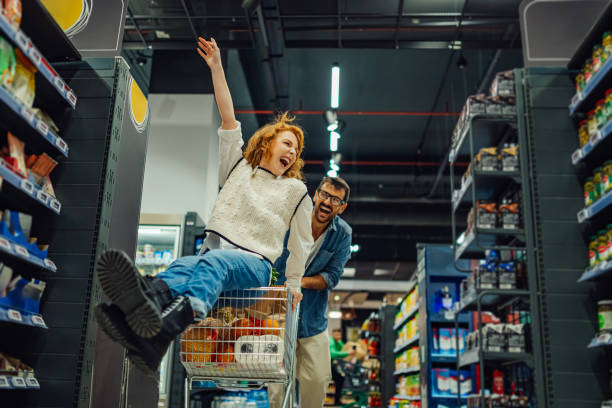 istock Cheerful couple having fun while shopping in supermarket 2186872009