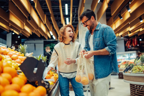 istock Cheerful couple choosing oranges at the supermarket 2186872012