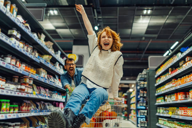 istock Young couple having fun while grocery shopping in supermarket 2186872032