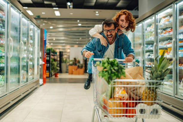 istock Young couple having fun while grocery shopping in supermarket 2186872037