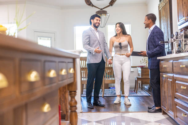 istock Hispanic Couple Looking at a home with a real estate agent 2186873664