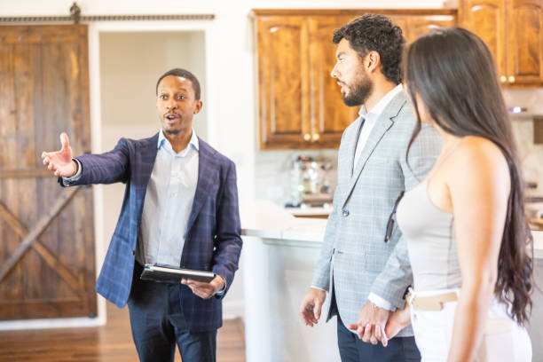 istock Hispanic Couple Looking at a home with a real estate agent 2186873835