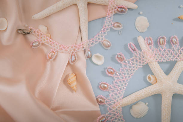 istock White and lilac beaded necklace with multicolored river pearls on starfish surrounded by seashells 2186878952
