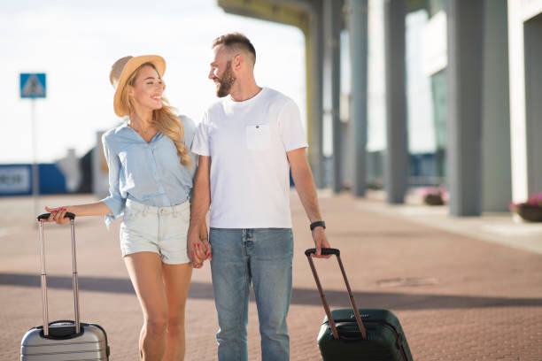 istock Happy couple walking in airport with baggage 2186887702