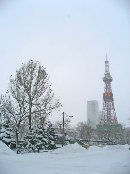 Sapporo Odori park winter scenery, TV tower with clock showing local time and deep snowdrifts