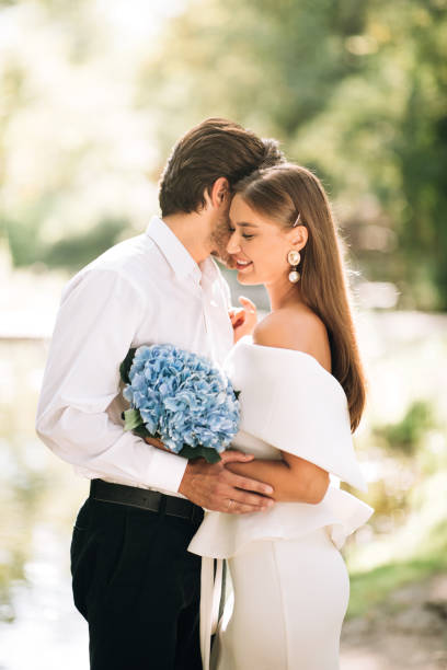 istock Newly-Wedded Couple Embracing Standing In Forest Outside, Vertical 2186893839