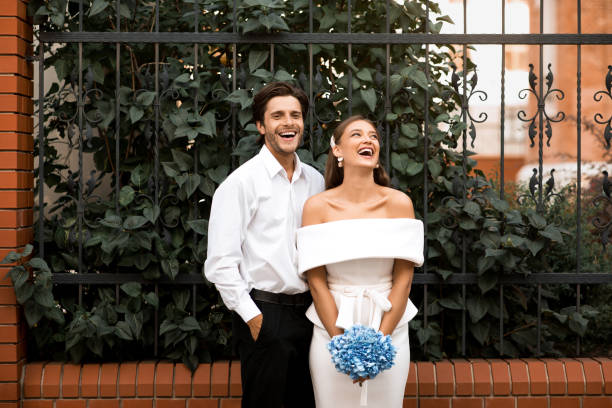istock Just Married Bride And Groom Laughing Standing Outdoors 2186893882