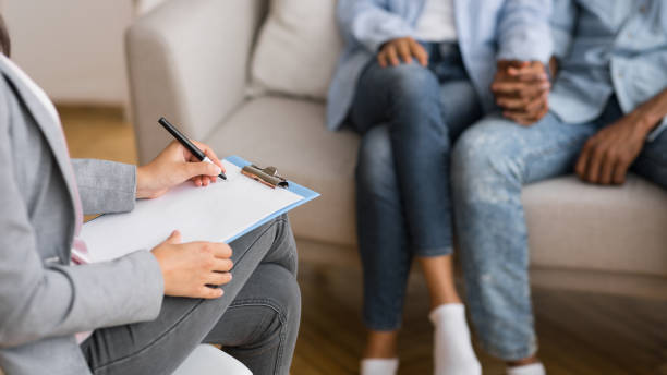 istock Afro couple holding hands on couch during marriage counseling session 2186894723